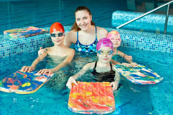 Νεαρή Κοπέλα Εκπαιδεύτρια Κολύμβησης Παιδιά Στην Πισίνα — Φωτογραφία Αρχείου