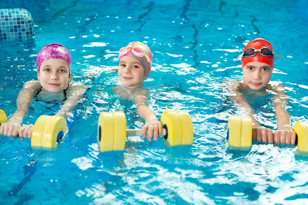 ダンベル付きのプールでの子供たちの訓練 水泳レッスン — ストック写真