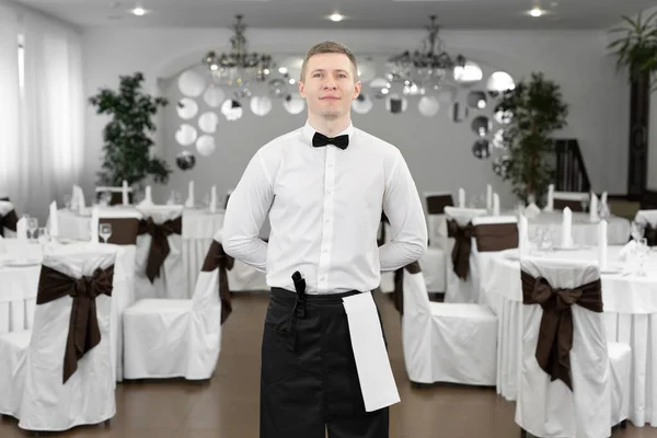 stock image Portrait of a male waiter in a white shirt in the banquet hall of a restaurant