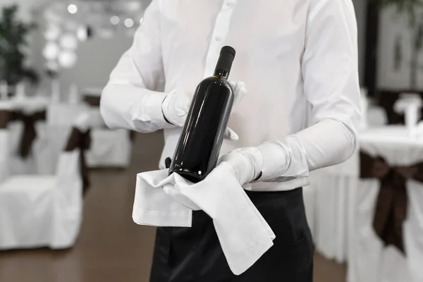 服务员手里拿着一瓶红酒的特写 — 图库照片