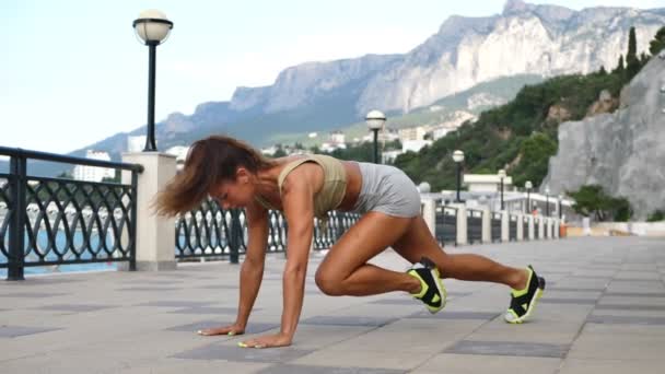 Μια Αθλητική Γυναίκα Κάνει Σωματικές Ασκήσεις Στο Ανάχωμα Την Αυγή — Αρχείο Βίντεο