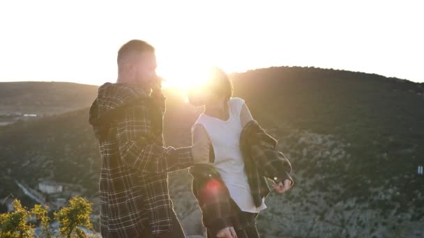 爱情中的男人和女人 在日落的时候 在俯瞰大海的悬崖上跳舞 玩得很开心 — 图库视频影像