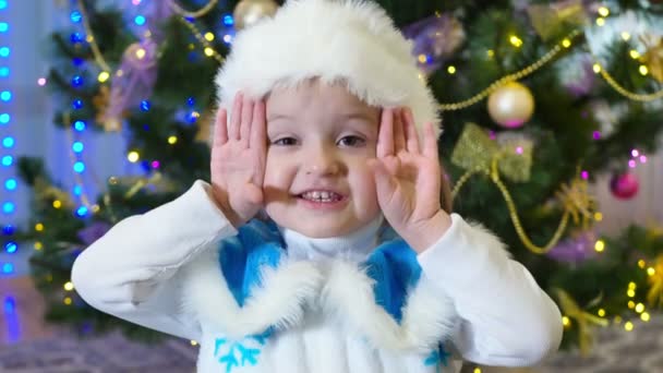 女の子でA雪の乙女の衣装クリスマスツリーの背景にある空気キス — ストック動画