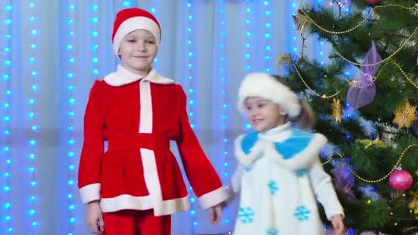 サンタクロースと雪の乙女抱擁のクリスマスの衣装の兄弟姉妹 — ストック動画