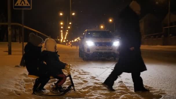 Mama Zabiera Dzieci Sanki Snowcat Drugiej Stronie Ulicy Zimie Nocy — Wideo stockowe