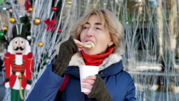 Bir Kadın Sıcak Bir Içecek Içer Kentin Sokaklarında Zencefilli Ekmeği — Stok video