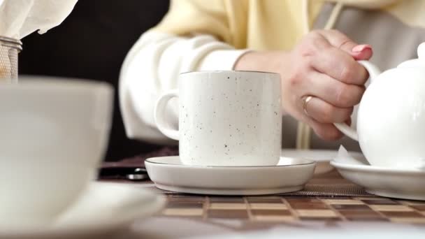 家人在咖啡店度假 妈妈把茶壶里的茶倒进杯子里 — 图库视频影像