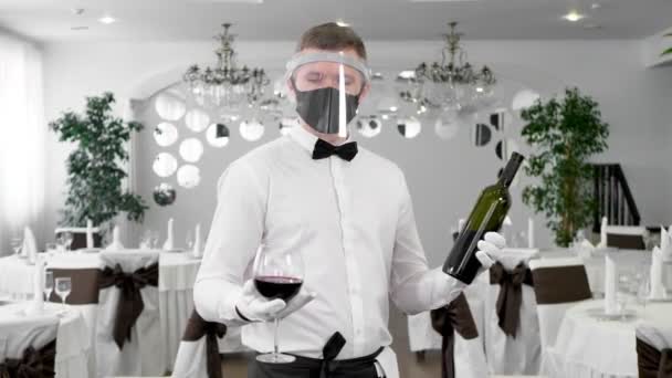 Ober Met Een Beschermend Masker Met Een Glas Rode Wijn — Stockvideo