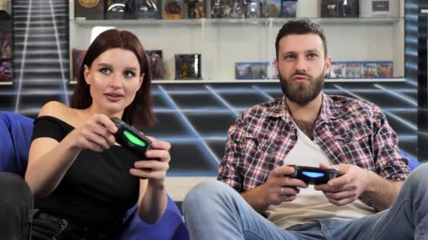 Fiatal Pár Videojátékozik Széken Ülnek Egy Játékklubban Kezükben Irányítókkal — Stock videók