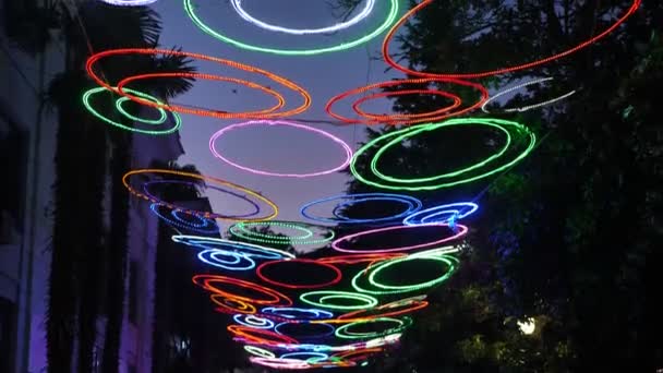 Grinaldas Forma Círculos Multicoloridos Pendurar Contra Fundo Céu Noturno — Vídeo de Stock
