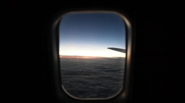 Bulutlar ve gökyüzü bir uçağın penceresinden görüldüğü gibi