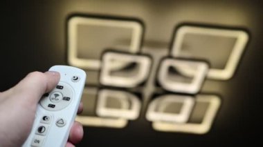 Işığı kontrol eden uzaktan kumanda. Tavanda neon avize var..