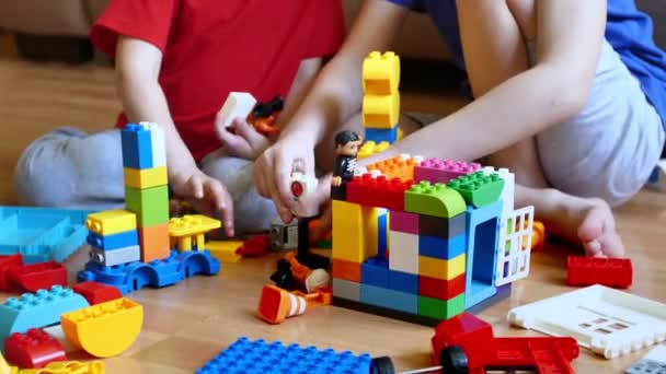 Çocuklar Yerde Çok Renkli Bir Inşaatçıyla Oynuyorlar — Stok video