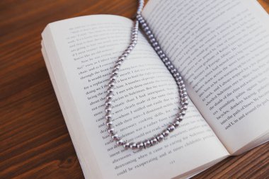 Bir kitap ayracı olarak kolye ile açılmış eski bir kitap.