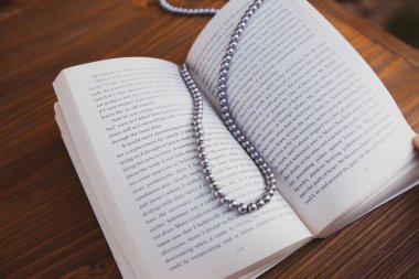 Bir kitap ayracı olarak kolye ile açılmış eski bir kitap.