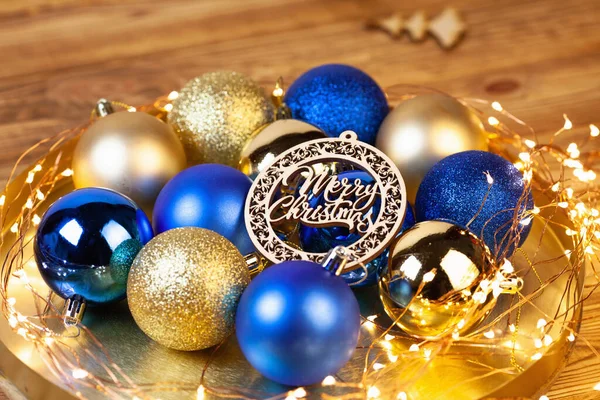 Kartu Natal Dengan Bola Emas Dan Biru Terang Piring Kayu — Stok Foto