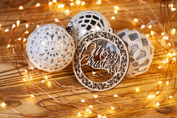圣诞贺卡 上面有明亮的银球和木制盘子 上面写着圣诞快乐的字样 球是用白色花边钩住的 — 图库照片