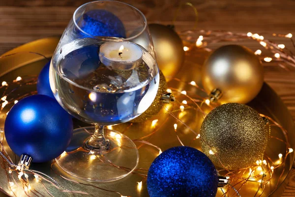 Tarjeta Navidad Con Brillantes Bolas Doradas Azules Vela Vaso Agua —  Fotos de Stock