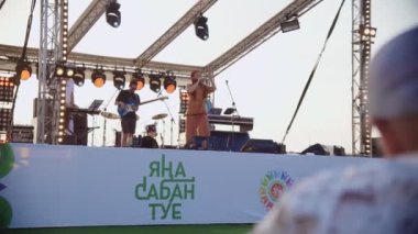 KAZAN, TATARSTAN RUSSIA - 27 Haziran 2021: Şarkıcı, festivalde yavaş çekim sırasında sahnede müzik grubuyla şarkı söyler. 27 Haziran 'da Kazan' da eğlenceli bir gösteri.