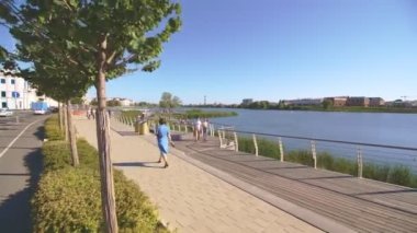 KAZAN, TATARSTAN RUSSIA - 06 Temmuz 2021: Güneşli bir günde şehrin tepesinde yürüyen insanlar için kaldırım ve ahşap teras. 6 Temmuz 'da Kazan' da nehir kenarında halka açık dinlenme yeri