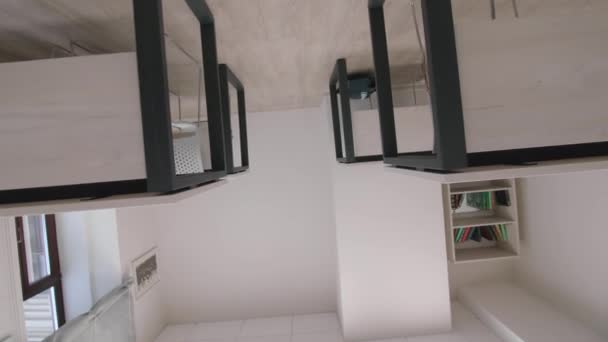 スタイリッシュな学生机は 空の教室のクローズアップカメラで書籍 学校や大学のための快適な家具 — ストック動画