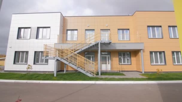 曇り空の下で近代的な学校の建物の安全な緊急階段 市内の公共の場所のための建築ソリューション — ストック動画