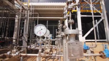 Güneşli bir günde kimyasal imalat fabrikasındaki boru hattı sisteminde basınç ölçerler. Fabrikada modern ekipman