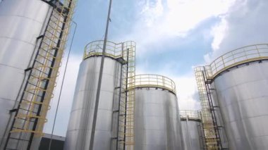 Karbon fiber üretim tesisinde servis merdivenleri olan yüksek yuvarlak çelik tanklar. Kimyasal maddeler işleniyor