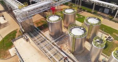 Kimyasal madde üretim tesisinin hava manzarasında parlak çelik tanklar ve boru hatları. Üretim endüstrisi tesisleri