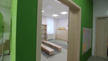 Modern anaokulunun boş soyunma odasında düşük ahşap banklar ve çocuk dolapları. Günlük bakım için mobilya düzenleme