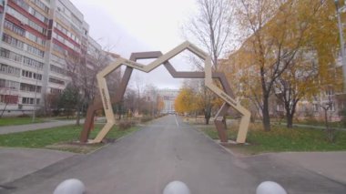 Geometrik kemer, şehirdeki çok katlı binalar arasında düz yolu olan küçük parkın girişinde. Sonbahar şehir bahçesi