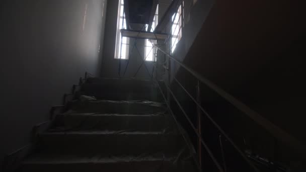 建筑工地摄像头转弯时 楼梯上覆盖着铝箔和靠近窗户的脚手架 恢复进程 — 图库视频影像