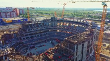 ALMATY, KAZAKHSTAN - 15 Eylül 2022: Atletik arena binasının beton iskeleti ve inşaat alanındaki yüksek vinçler. 15 Eylül 'de Almaty' de kentsel gelişim
