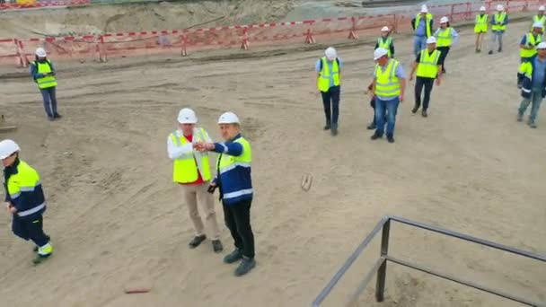 2022年8月10日 エンジニアはスタジアム建設現場でカメラマンが撮影中に検査官に報告する アルマトイでの8月10日の建物の管理プロセス — ストック動画
