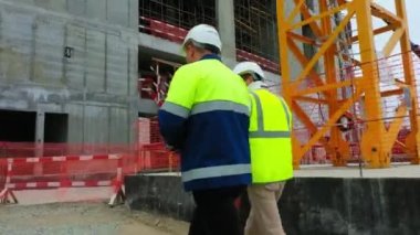 ALMATY, KAZAKHSTAN - 10 AĞUSTOS 2022: görev müdürü ve atış ekibi inşaat alanı boyunca yürür. 10 Ağustos 'ta Almaty' de halk spor merkezinin kontrolü