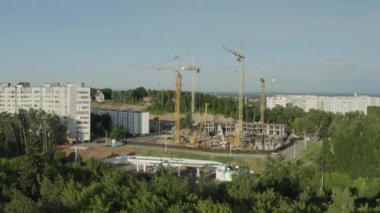 Beton bina iskeleti ve yüksek vinçler şehrin hava manzaralı şantiyesinde. Kentsel gelişim teknolojisi