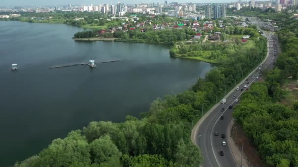 Estrada Moderna Com Carros Condução Perto Lago Tranquilo Contra Cidade — Vídeo de Stock
