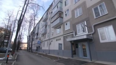 Kış günü şehirde gri cepheli ve balkonlu eski apartman dairesi. Yenilenmiş konut