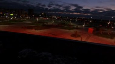 ALMATY, KAZAKHSTAN - 10 Eylül 2022: Aydınlatılmış spor arenası ve geceleri geniş şehir parkı üzerinde uçuş. Şehrin modern mimarisi 10 Eylül 'de Almaty' de