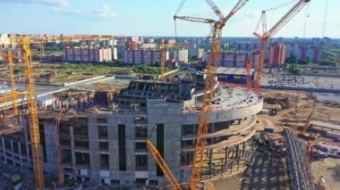 ALMATY, KAZAKHSTAN - 15 Eylül 2022: Bitmemiş spor stadyum binası ve inşaat alanındaki havadan görüş alanındaki yüksek kule vinçleri. 15 Eylül 'de Almaty' de kentsel bölge gelişimi
