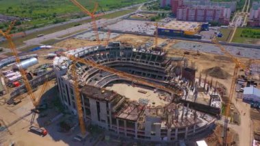 ALMATY, KAZAKHSTAN - 15 Eylül 2022: Geleceğin spor arena binası ve şehir hava manzaralı inşaat alanındaki kule vinçleri. 15 Eylül 'de Almaty' de kentsel alan gelişimi