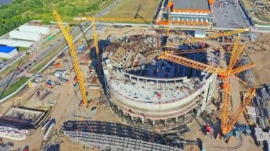 Gökdelen manzaralı inşaat alanında büyük vinçler spor sahasının yakınında çalışır. Şehir mimarisi