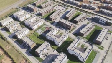 Şehir bloğu, çok katlı binalar ve güneşli gün kuşbakışı manzaralı çimenler. Banliyö bölgesinin çağdaş mimarisi