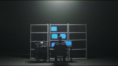 ALMATY, KAZAKHSTAN - AUGUST 22 2022: Security guards in control office with blue chromakey monitors zoom in. Digital technology of professional supervision on August 22 in Almaty