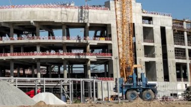 Timelapse of different machines working at sports center building construction site on sunny summer day. Urban architecture
