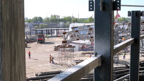 晴れた日にスポーツ競技場建設現場で強力なクレーンによって下げられた大きな金属屋根フレームの詳細のタイムラプス — ストック動画