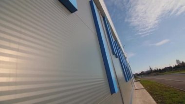 Commercial building with blue decorative details on grey facade on city street close low angle shot. Architectural project