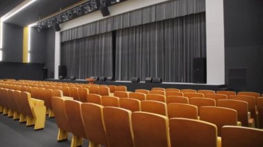 Chair rows and stage with black curtain in empty hall of theatre. Enclosure with furniture and space for performance