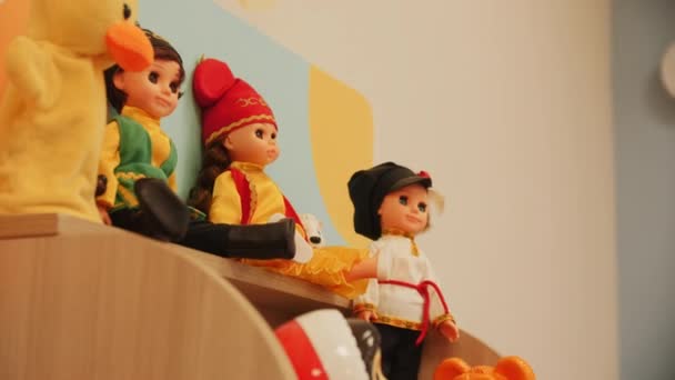 幼稚园游戏室特写镜头的木制架子上穿着民族服装的娃娃 幼儿古董玩具 — 图库视频影像