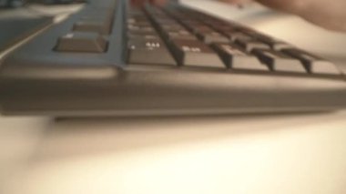 Motion over computer keyboard while woman types at table close first point view. Office equipment for employees